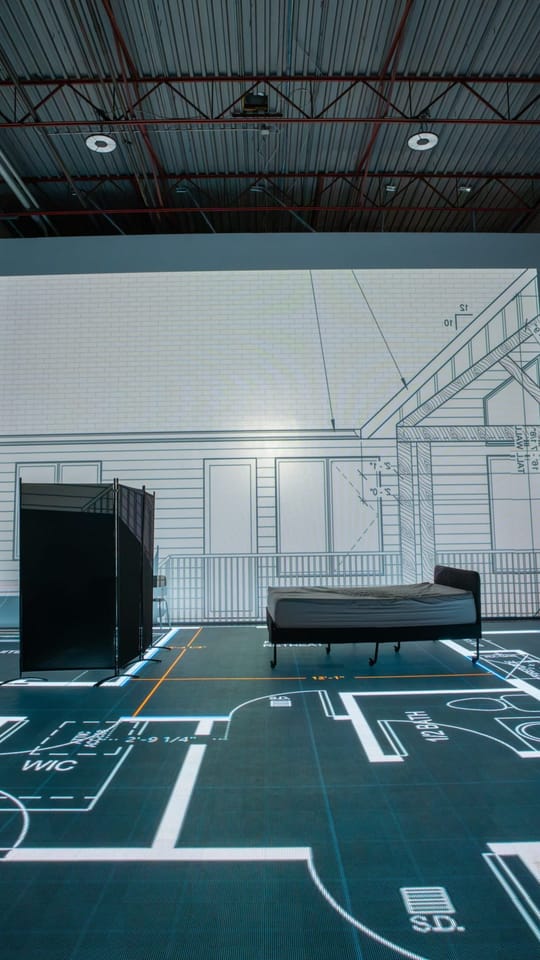 Walking a floor plan at full size in the Calgary studio, sofas and chairs set out on it