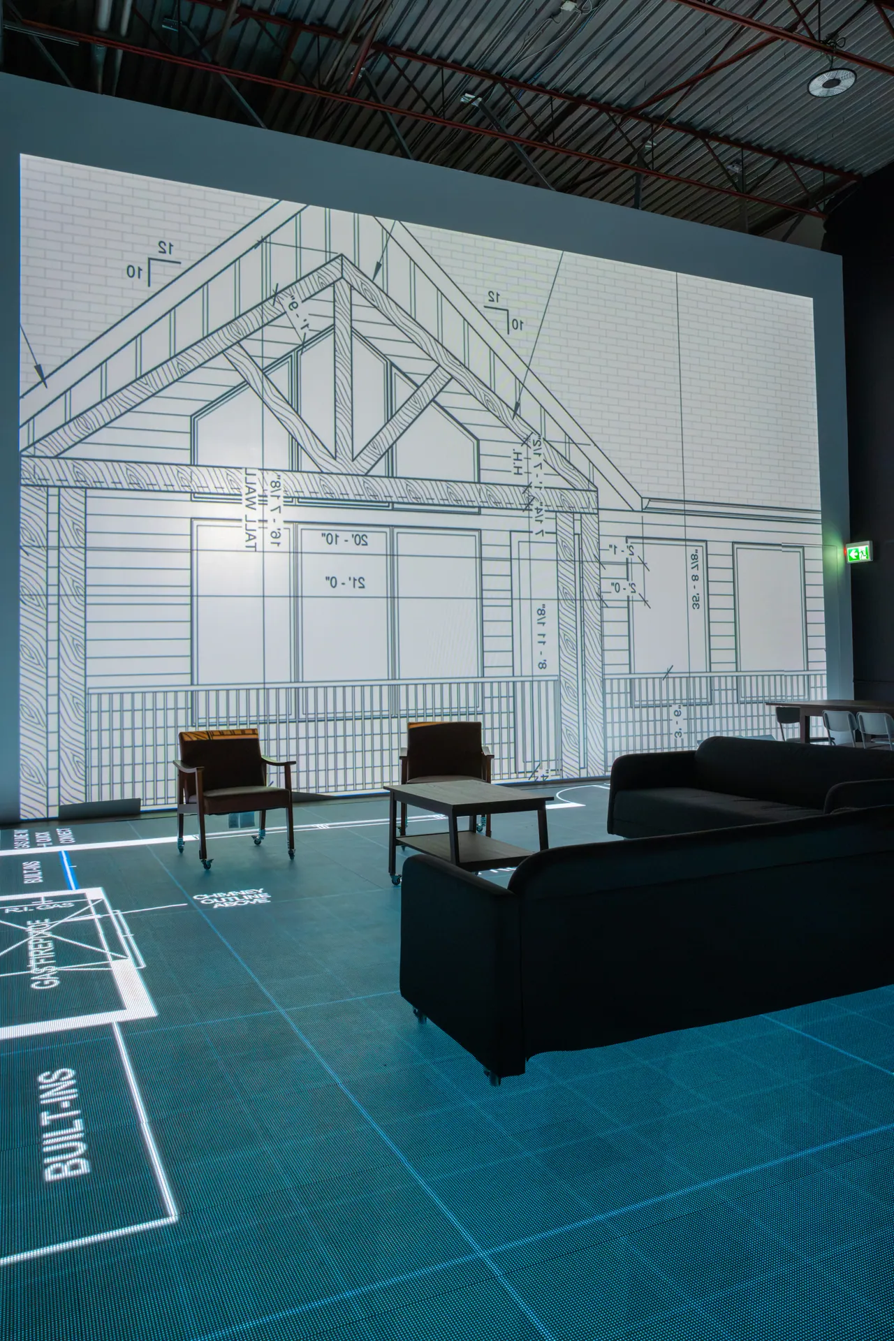 Living room furniture in front of the wall-size elevation screen